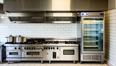 Commercial kitchen equipment including burner range, display counter, and refrigerator